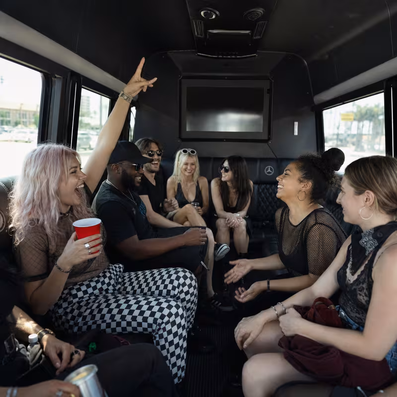 Group boarding a white charter bus for Concert Transportation transportation in Los Angeles
